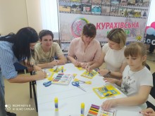 Діти й дорослі створюють тематичні лепбуки до Дня Конституції України під час творчого заняття у Курахівській громаді.