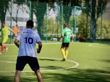 Спортсмени на футбольному полі. Один спортсмен одягнений у білу футболку з надписом ДСНС Краматорськ, інший у зеленому