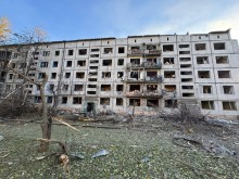 Пошкоджена багатоповерхова будівля та вибиті вікна