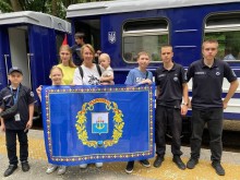 Фото родини з Маріуполя з прапором міста на дитячій залізниці