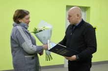 Юрій Винокуров вітає працівницю ЖКГ, дарує квіти та вручає почесну грамоту.