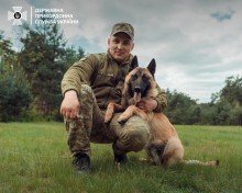 Український прикордонник обіймає службового собаку