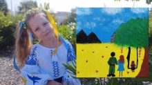 Дівчинка, вихованка Донецького обласного палацу дитячої та юнацької творчості, демонструє власний малюнок: родина на синьо-жовтому тлі. На горизонті - терикони.