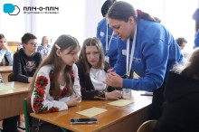 Вчитель показує, як робити Великодні свічки, дівчата за партою уважно дивляться.