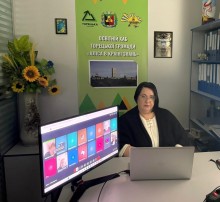 Представник військової адміністрації сидить за столом та слухає доповідача на семінарі