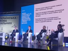 Панельна дискусія за участю чотирьох спікерів, які сидять у кріслах на тлі екрана з програмою заходу.