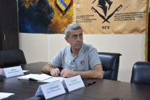 Учасник наради, сидить за столом та уважно слухає доповідь громад.