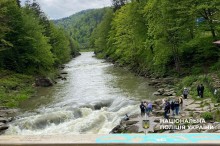 Група людей спостерігає за течією гірської річки