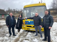 Представники громад стоять біля автобуса та тиснуть один одному руки.