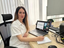 Представник військової адміністрації сидить за столом та слухає доповідача на семінарі