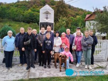 Спільне фото,біля рідкісной скульптури бджоли в мармурі. На передньому плані маленька дівчинка у рожевій курточці та велика собака.