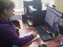 Представник військової адміністрації сидить за столом та слухає доповідача на семінарі