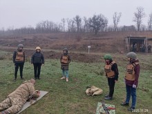 лухачі другої групи підготовки уважно слухають інструктаж інструкторів перед початком практичних вправ на полігоні. Учасники зосереджено готуються до відпрацювання тактичних навичок у польових умовах.