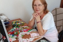 Учасниця семінару за ноутбуком, на столі розкладено традиційні віночки та старовинні фогографії