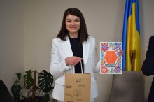начальниця Старомлинівської сільської військової адміністрації Альона Лєфтєрова ттримає книгу про Софіївську громаду