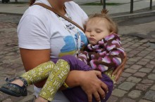 Волонтерка тримає евакуйовану дівчину, яка заснула, на руках.