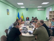 Представники громад та правоохоронних органів, які сидять за столом.   Очолює нараду в.о. голови Краматорської райдержадміністрації, начальника районної військової адміністрації Вікторія Набокова. На столі лежать книги про Донеччину.