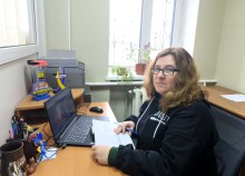 Представник військової адміністрації сидить за столом та слухає доповідача на семінарі