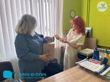 Представник Покровської громади презентує колезі із відділу культури пакет, в якому сувеніри громади.
