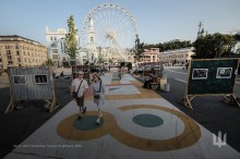 Фотовиставка на Контрактовій площв. З обох боків інсталяція війни та фотографії.