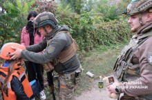 Поліцейський вдягає каску на дитину