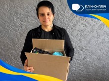 Жінка тримає коробку з гуманітраною допомогою