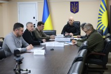 Учасники засідання комісії сидять за столом