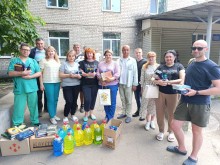 Спільне фото захисників та захисниць разом з представниками Мирноградської громади з книжками, буклетами та гігієнічними наборами.
