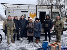 Група людец поруч з евакуаційним автомобілем та рятувальниками групи "Фенікс"