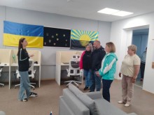 Представниця центру підтримки переселенців проводить екскурсію по приміщенню центра