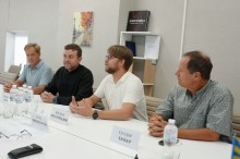 Учасники зустрічі сидять за столом