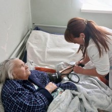 Лікарка міряє тис літній жінці