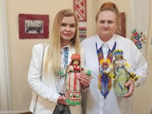 Дві жінки тримають ляльок-мотанок