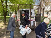 Рятувальники допомагають літнім людям сісти в евакуаційний автомобіль
