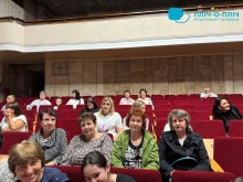 Глядачі у концертному залі сидять на стільцях.