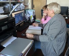 Представник військової адміністрації сидить за столом та слухає доповідача на семінарі