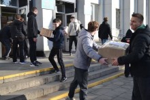 Молодь заносить коробки з гуманітарною допомогою