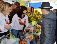 Ярмарок сувенірної продукції. Позаду прапори. На столах соняшники.