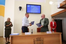 Кременчуцький міський голова Віталій Малецький та начальник Часовоярської міської військової адміністрації Сергій Чаус передають один одному підписані меморандуми.