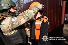 Поліцейський одягає захисний шолом на дитину.