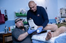 Бригада парамедиків надають першу медичну допомогу,накладають шину на ногу пораненого.