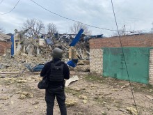 Правоохоронець стоїть біля зруйнованих ворогом будинків