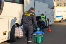 Рятувалньик вантажить речі до автобусу