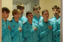 Група спортсменів під час засідання колегії співає гімн