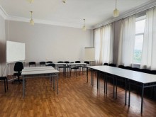 Шкільний клас. Нові парти білого кольору та чорні стільці. Великі вікна