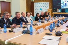 Представники Донеччини та громад-партнерів на нараді. Жінки та чоловіки сидять за круглим столом та обговорюють питання про співпрацю.