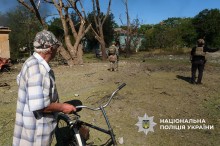 Чоловік з велосипедом дивиться на поліцейських