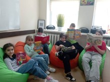 Група дітей читає книжки, сидячи на кріслах-пуфах