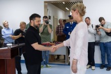Президент України тисне руку лікарці перед нагородженням.