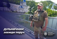 Дільничний офіцер у повній екіпіровці, на задньому плані - Святогірська Лавра.